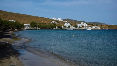 A secluded beach overlooking a coastal settlement and the calm sea, Analipsi, Maltezana, Astypalea,