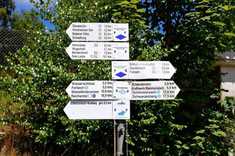 Hiking trail signpost in Forbach, Black Forest, Germany showing directions and distances to nearby
