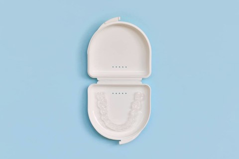 Customized transparent dental teeth bite guard clear aligners for lower jaw in white case on blue