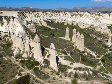 High rock towers rise in an impressive valley scenery in Cappadocia, aerial view, Love Valley,