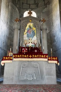 Church altar with religious symbols and icon, decorated with red cloths and candles, Sisian,