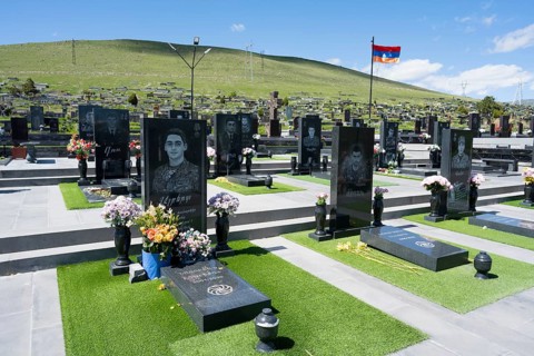 Cemetery with memorial plaques and flowers, peaceful atmosphere under a blue sky, graves of 2020,
