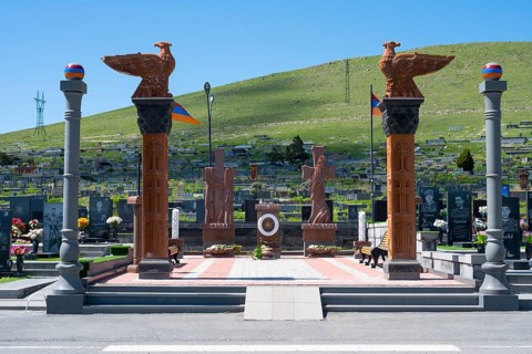 Impressive monument with eagle statues in a peaceful cemetery setting, memorial to the heroes of