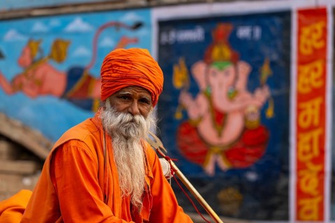 Indian Sadhu, with picture of Ganesha in the background, Bangali Tola, Varanasi, Uttar Pradesh,
