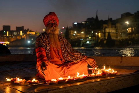Sadhu on boat, burning candles, Mughalsarai, Uttar Pradesh, India