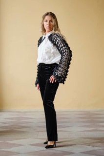 Brightly lit indoor location displays a middle-aged fashion model standing confidently. She wears a