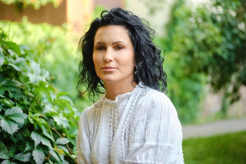 Bright and peaceful atmosphere surrounds a woman with curly black hair as she sits gracefully among