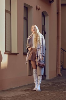 The young woman exudes confidence in a chic autumn outfit featuring a brown skirt and white