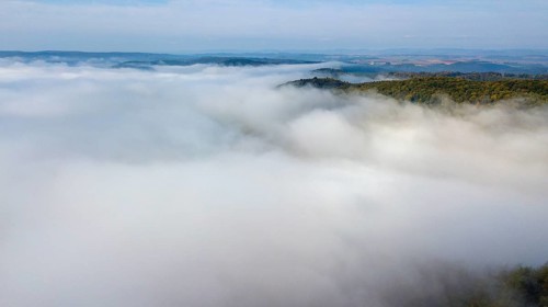 Bird's eye view of aerial view of high fog lying over valleys of low mountain ranges, Germany