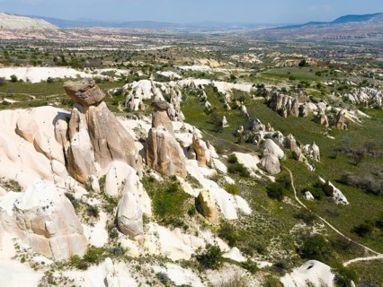 Rock formations and green areas in a hilly landscape with a wide view, aerial view, fairy chimneys