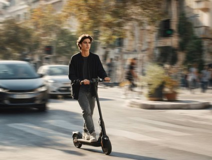 Ein Teenager nimmt mit einem E-Scooter am öffentlichen Straßenverkehr in einer Stadt teil,