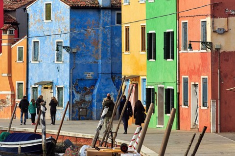 Strollers along the canal, typical street scene in winter, colourful facades in Burano, island in