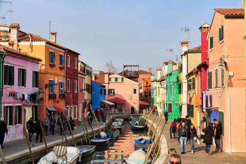 Strollers along the canal, typical street scene in winter, fishermen's houses in different colours,