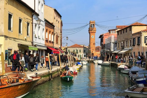 Strollers along the canal, typical street scene in winter, campanile of the church of San Giacomo,