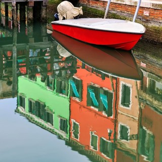 Colourful façade details reflected in the water of a canal, motorboat, Burano, Venice, Veneto,