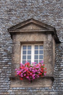Dormer window with glazing bars in a historic house, floral decoration, old town of Guingamp,