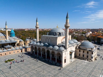 Spacious mosque complex with wide squares and several minarets under a clear sky, aerial view,
