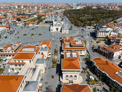 Bird's eye view of town square and surrounding buildings with characteristic red roofs, aerial