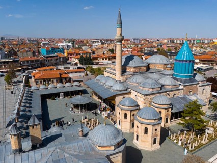 Historic mosque with large domes and minarets in the city centre under a clear sky, aerial view,
