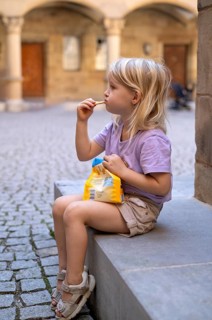 Girl, 4 years, blonde, summery dressed, sitting on step, eating biscuits, summer, Stuttgart,