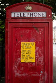 Red London telephone box with yellow poster, Kensington, London, England, Great Britain