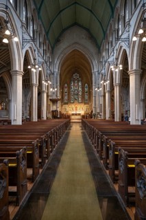 Neo-Gothic church interior with high arches and wooden benches, St Mary Abbot Church, Kensington,