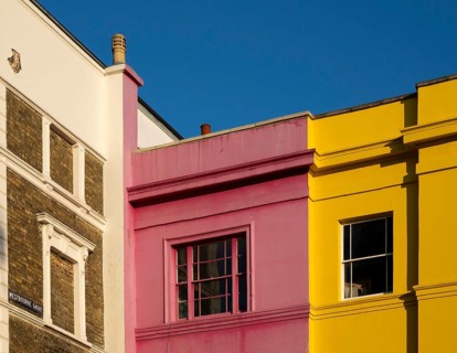 Colourful building facades in pink, yellow and white, blue sky, Portobello Road, Notting Hill,