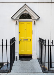 Bright yellow front door with house number five and neoclassical triangular gable, Palladian-style
