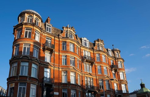 Large red brick building with bay windows and balconies, Notting Hill, London, England, United