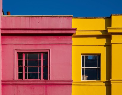 Colourful building facades in pink and yellow, blue sky, Portobello Road, Notting Hill, London,