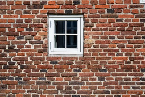 Close-up of a brick wall with a small white window, Old Town, Ringkøbing, Ringkøbing Fjord, Denmark