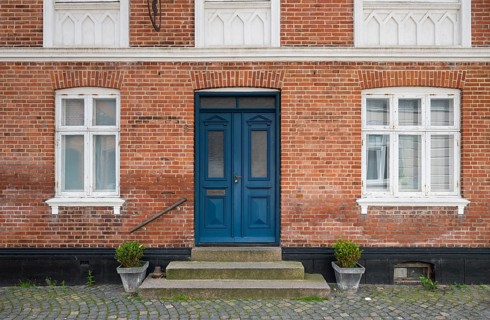 Brick façade with a striking blue door and potted plants, Old Town, Ringkøbing, Ringkøbing Fjord,