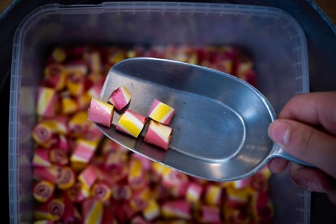 Colourful sweets are taken out of a container with a ladle, Ringkøbing, Ringkøbing Fjord, Denmark
