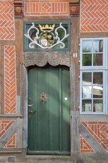 Door with coat of arms and golden crown at the entrance to the Eulenspiegel Museum, half-timbered