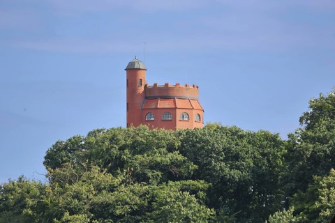 Red water tower with battlements built in 1913, looking out of the forest, spire, Mölln,