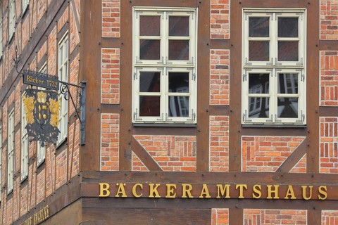 Nose plate with golden year on a brick house, half-timbered house, house facade, window, wrought