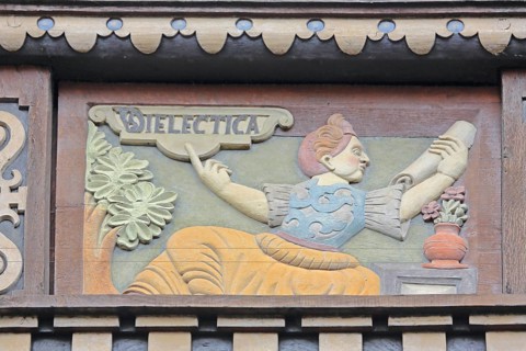 Allegorical woodcarving with figure on dialectics, philosophy, rhetoric talk, conversation, scroll,
