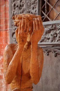 Wooden figure with hands in front of the face, interior view, wooden sculpture, modern art, wood