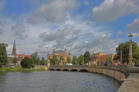 View over the castle lake to the castle bridge with tower of the cathedral, state theatre and state