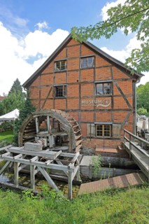 Grinding mill with brick building and water wheel, mill wheel, wooden construction, inscription,