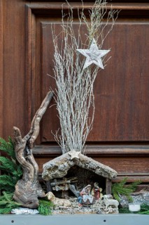 Detailed nativity scene scene with wood and decorative star, surrounded by natural elements,