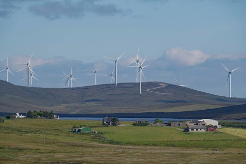 Wind farm on green hills under blue sky with clouds, rural environment, Shetland Islands, Scotland,