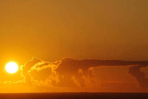 Sunset over the sea with intense orange clouds, crossing between Orkney and Shetland Islands,