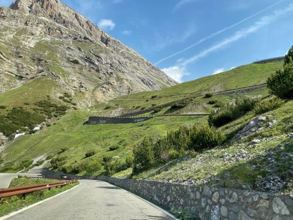 View of the Alpine road in front Mountain road at tree line, in the centre of the picture