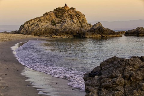 Rocky beach at sunset with gentle waves and a calm atmosphere, Ricadi, Capo Vaticano
