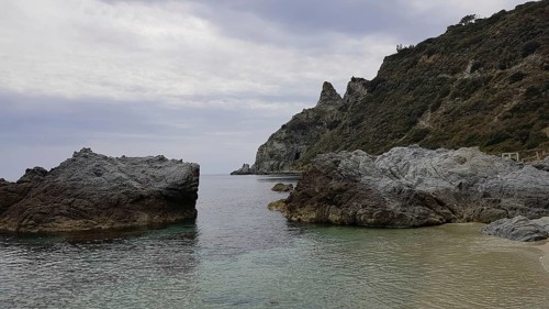 Barren rocky landscape on the coast under a cloudy sky with calm sea, Ricadi, Capo Vaticano