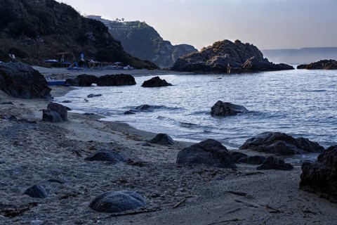 Coastline at dawn with dark rocks and calm sea, Ricadi, Capo Vaticano