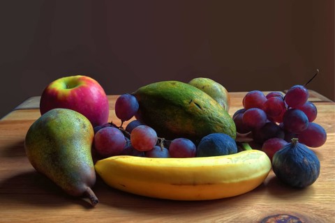 Fresh fruit arrangement of pears, grapes and bananas on a wooden table, Willich, North