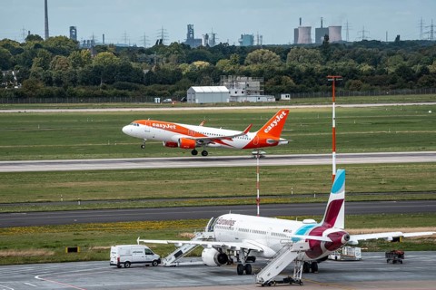 Düsseldorf Airport, Eurowings Airbus aircraft on the apron, EasyJet Airbus A320-200 taking off, in