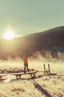 Young woman at Lake Staz near Sankt Moritz in the Engadine in Switzerland. Morning atmosphere with